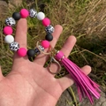 Close-up of silicone bead keychain wristlet with leopard print and pink PU tassel charm - Rose Red