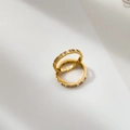 Dettaglio di due anelli dorati sovrapponibili con trama rettangolare e cristalli - US 6 / Zirconia Bianca Doppia