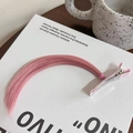 Pink synthetic hair extension clip for cosplay styling on a white book background - Light Pink