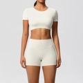 Detail von elfenbeinfarbenem Yoga-Set mit Kurzarm-Crop-Top und High-Waist-Sportshorts - S / Oberteil Und Unterteil / Helles Elfenbein