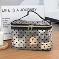 Portable black mesh heart makeup bag with golden star zipper and top handle on wooden table - Black