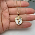 Close-up of golden shell necklace with white mother of pearl and floral detail - Style F