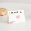Carte de vœux 'GOOD LUCK' minimaliste avec cœur rose et décorations d'étoiles jaunes - Bonne chance