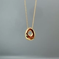 Close-up of golden teardrop hollow pendant with polished mirror finish on thin chain - Letter O Single Pendant
