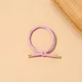 Detail view of pink elastic hair tie with textured ribbing and gold metal caps on beige background - Ribbed Knot - Metal Buckle / Girl Pink