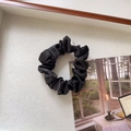 Close-up of black satin scrunchie with glossy pleated texture on a clean white background - Small / Black