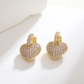 Macro shot of gold heart-shaped earrings featuring pink-purple pavé-set cubic zirconia - Pink