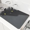 Dettaglio del tappetino assorbente nero da cucina su bancone bianco con un bicchiere - 30x40cm / Grigio Scuro Minimalista