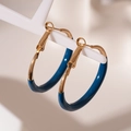Dettaglio ravvicinato di orecchini a cerchio dorati a forma di C con smalto blu scuro - Orecchini a cerchio in goccia d'olio blu