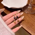 Vintage gold and brown stone drop earrings held by hand for size reference - A1973 Gold