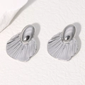 Pendientes minimalistas de acero plateado con textura de concha sobre fondo de roca - Color Acero