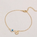Gold evil eye bracelet with 14K gold plating and letter A charm on white fabric - Letter A Style (BR0034)