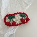 Close-up of handmade crochet cherry hair clip with white base and red scalloped edges - Crochet-Two Red Cherries
