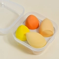 Detail of four colorful water-drop makeup sponges in a clear square storage case - 4-Grid Mango Yellow Box