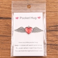 Red enamel heart with silver wings pocket hug token on a poetic white message card - Vintage Red Heart with Single Wing