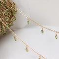 Macro shot of gold plated DIY jewelry chain with translucent green round pendant dangles - Gold Chain - Green Stone