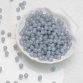 Round 6mm translucent grey-blue glass beads in a white shell-shaped porcelain dish - Light Grey Chalcedony Beads (6mm)