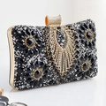 Detail of evening clutch featuring black gemstones and golden rhinestone wing buckle - Black