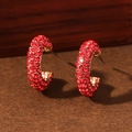 Fashionable C-shaped gold alloy earrings with dense red rhinestones on a wooden base - Red With KC Gold
