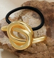 Close-up of golden abstract knot hair tie on natural rock with black elastic band - Style 3-Abstract Twist Design / Gold