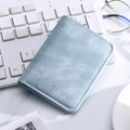 Portacarte sottile in pelle azzurra con logo goffrato su una tastiera bianca lucida - Blu