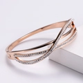 Detail van roségouden overkapte armband met een dubbele rij glanzende zirkonia kristallen - Roségoud
