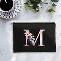 Black canvas cosmetic bag featuring a large pink letter M with floral rose accents - Letter M