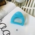 Close-up of a translucent blue geometric triangle hair claw clip on a white book base - Medium (approx. 6cm) / French Blue