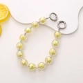 Detail of colorful faceted acrylic beads with metallic spring ring clasps and lemon accent - Yellow