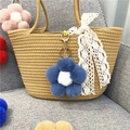 Adorable blue plush flower pom-pom keychain charm hanging on a stylish woven straw handbag - 1 Piece / Haze Blue