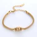 Goldenes Edelstahl-Mesh-Armband mit mattierter Perle und Karabinerverschluss auf Weiß - Gold