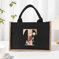 Black canvas tote bag featuring floral letter T print and natural jute trim handle - Bronze Floral Letter T