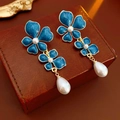 Detalle macro de pendientes de flores de esmalte azul con baño de oro y perla de gota - Azul (Pin de plata 925)