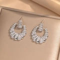 Pendientes circulares de plata con circonitas sobre una bandeja metálica dorada - Pendientes de Botón de Concha Color Acero (249)