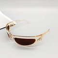 Close-up of transparent resin sunglasses with brown lenses and silver moon emblem - Champagne Frame Tea Lens