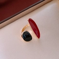 Detailed shot of open ring featuring red and black enamel ends on a satin background - Red