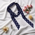 Detalle de cerca de pañuelo estrecho azul oscuro con lunares con rosas y frasco de perfume - Azul Oscuro Lunares Grandes