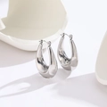 Macro shot of silver U-shaped titanium steel earrings with high-polished mirror finish - Steel Color Geometric Circle