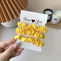 Set of three bright yellow satin hair scrunchies displayed on a white branded card - 3 Piece Set / Yellow