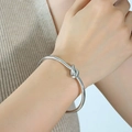 Silberner Armreif mit Knotendesign im minimalistischen Stil am Handgelenk einer Frau - Grober Knotenstil (Z128) / Stahlfarbe