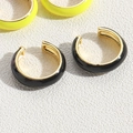 Close-up of vibrant enamel C-shaped ear cuffs in black and yellow gold finish - Black