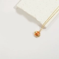Gouden vis choker halsketting met oranje emaille hanger op witte textuur steen - Oranje