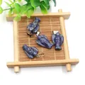 Natural sodalite gemstone angel wing pendants with silver metal clasps on bamboo mat - Blue Sodalite