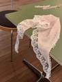 Pink silk triangle headscarf with white lace edges and soft pom-poms on green table - Pink French Lace Triangle Scarf