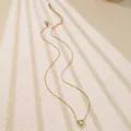 Detail of a minimalist gold chain necklace featuring a heart-cut green gemstone pendant - Green Heart Style (BD021-green)