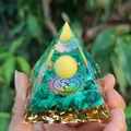 Orgone crystal pyramid with green stones and Om symbol held in hand for home decor - Style 55