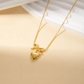 Collier en acier au titane doré orné d'un nœud papillon et d'un pendentif cœur - Collier Cœur Nœud Papillon
