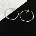 Macro shot of silver twisted hoop earrings with irregular flowing design on black fabric - Clip-on Style / 4cm / Silver