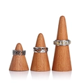 Three silver stainless steel rings with floral and geometric patterns on wooden cone stands - Beech Wood Ring Cone Set S/M/L