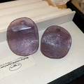 Macro shot of purple textured resin disc earrings with a glossy brushed finish in a box - Purple